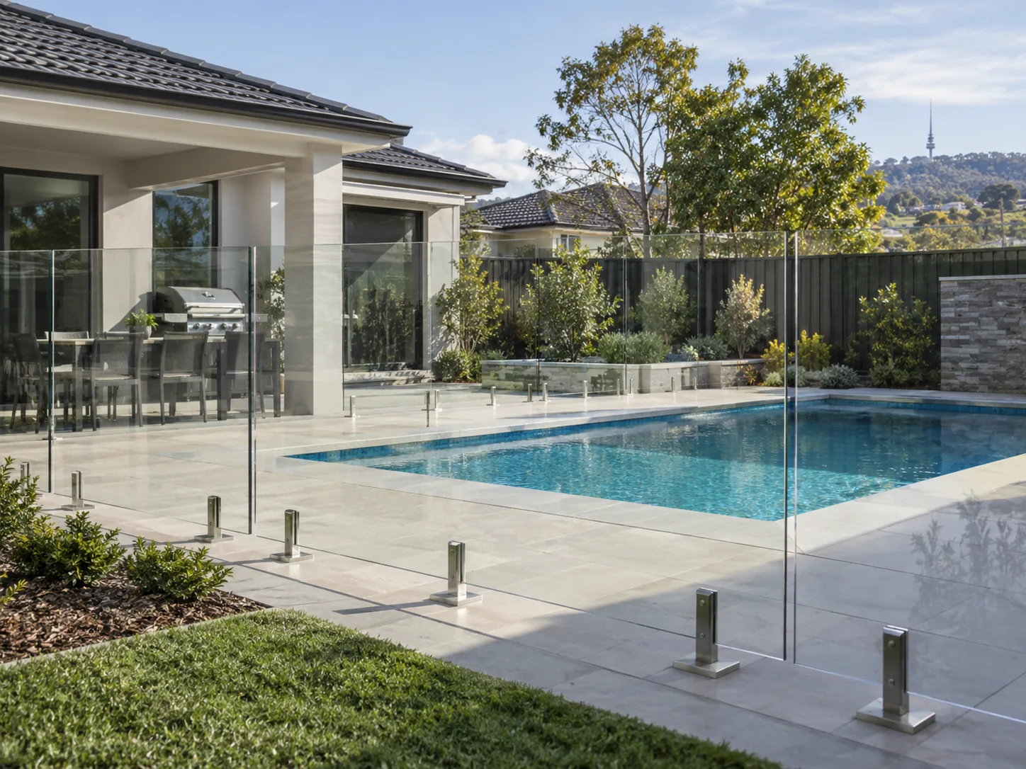 Illustrative glass fencing around a backyard swimming pool.